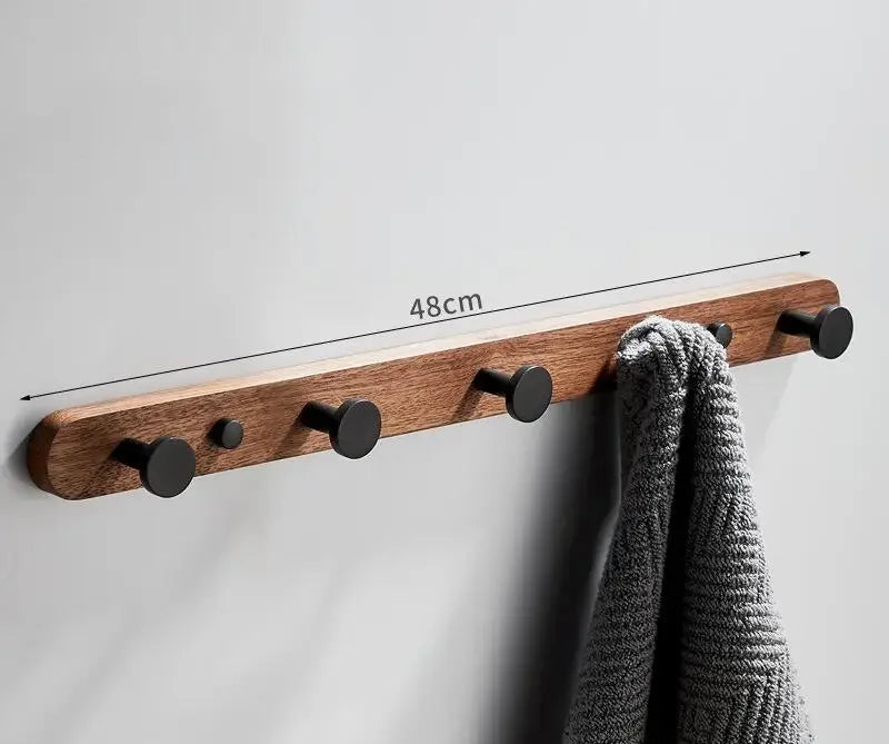Wall-mounted walnut wood towel rack with metal bars and folded towels