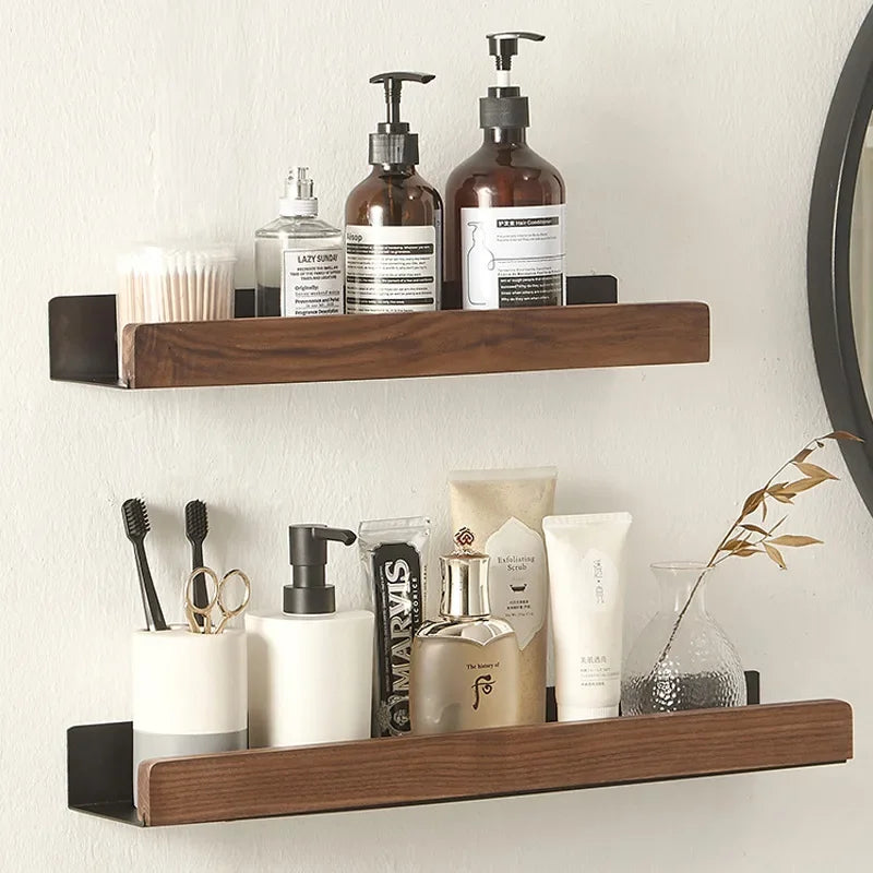 Walnut wood floating bathroom shelves holding soap dispensers and skincare products