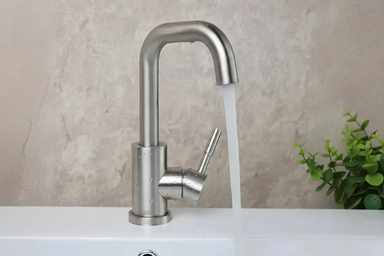Stainless steel single-handle bathroom basin mixer tap installed on sink with running water