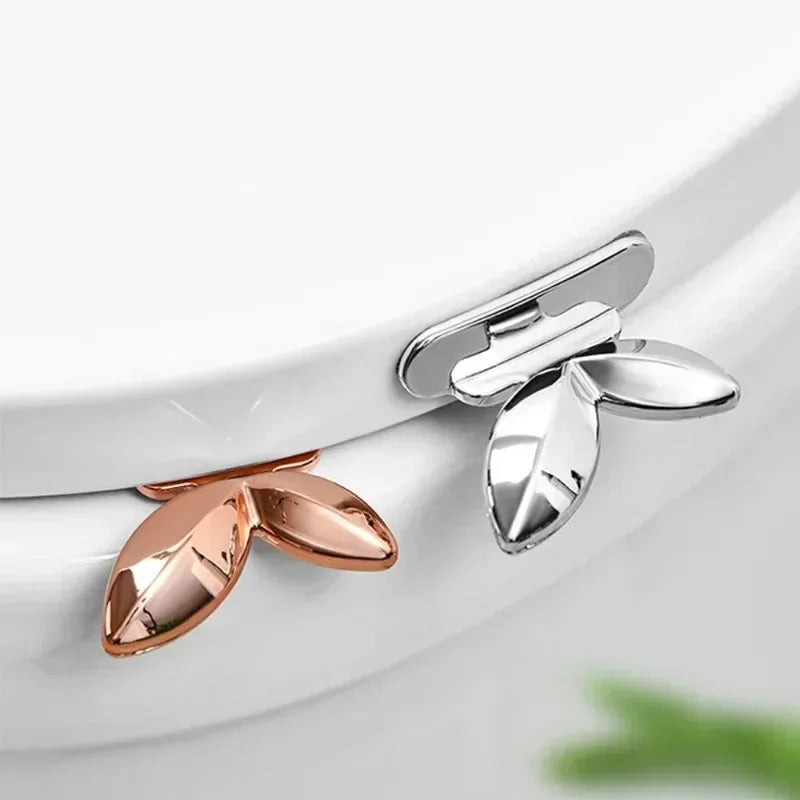 Silver and rose gold toilet seat lid lifter handles mounted on toilet