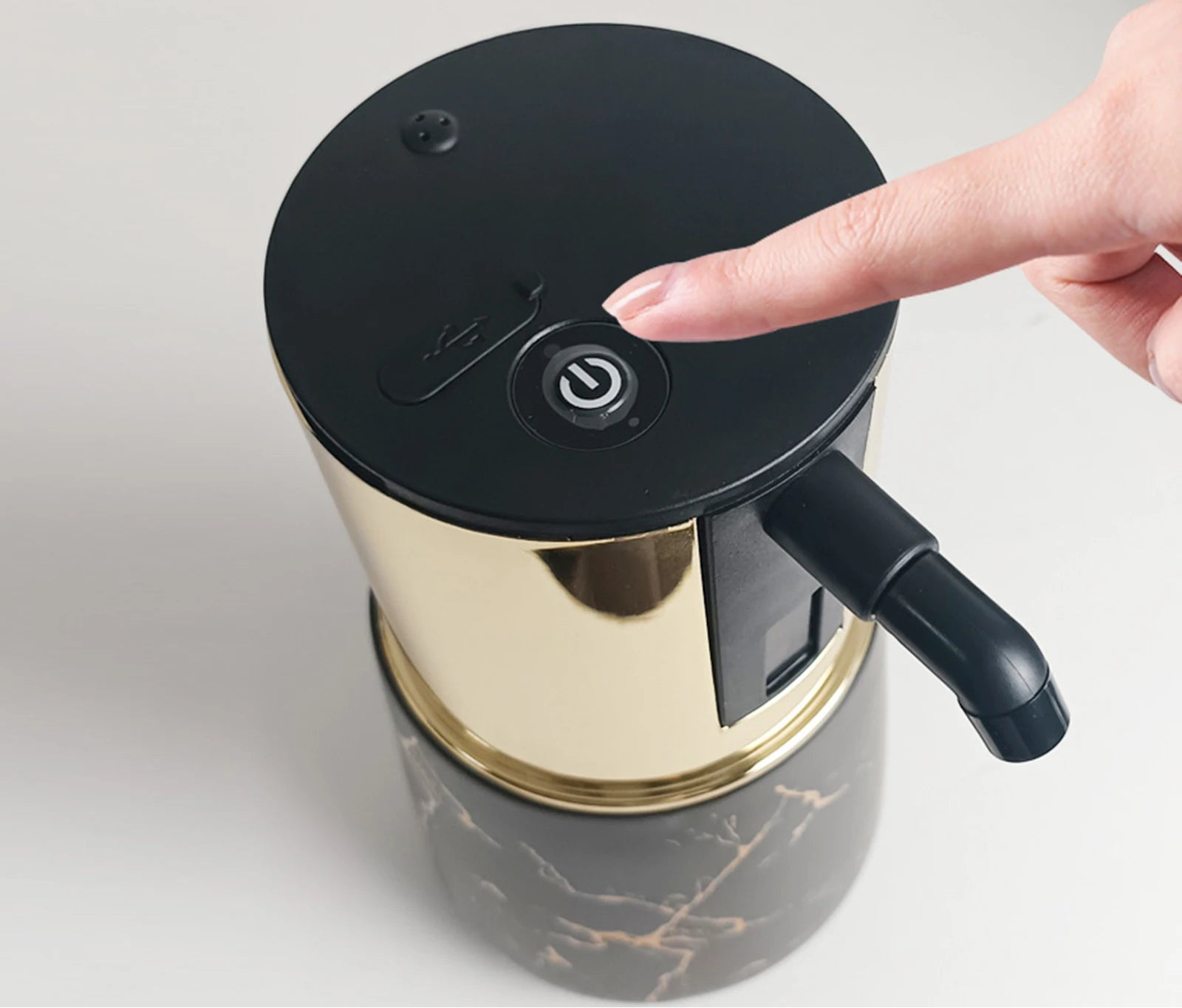 Rechargeable touchless soap dispenser showing power button detail